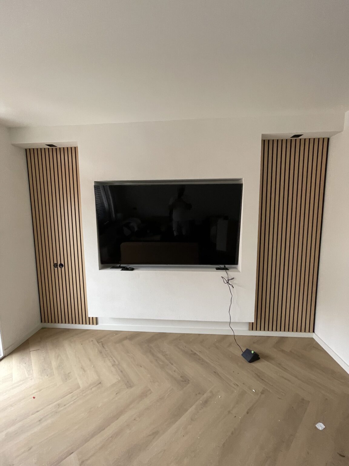 Tv-wand met lattenpanelen en visgraatvloer